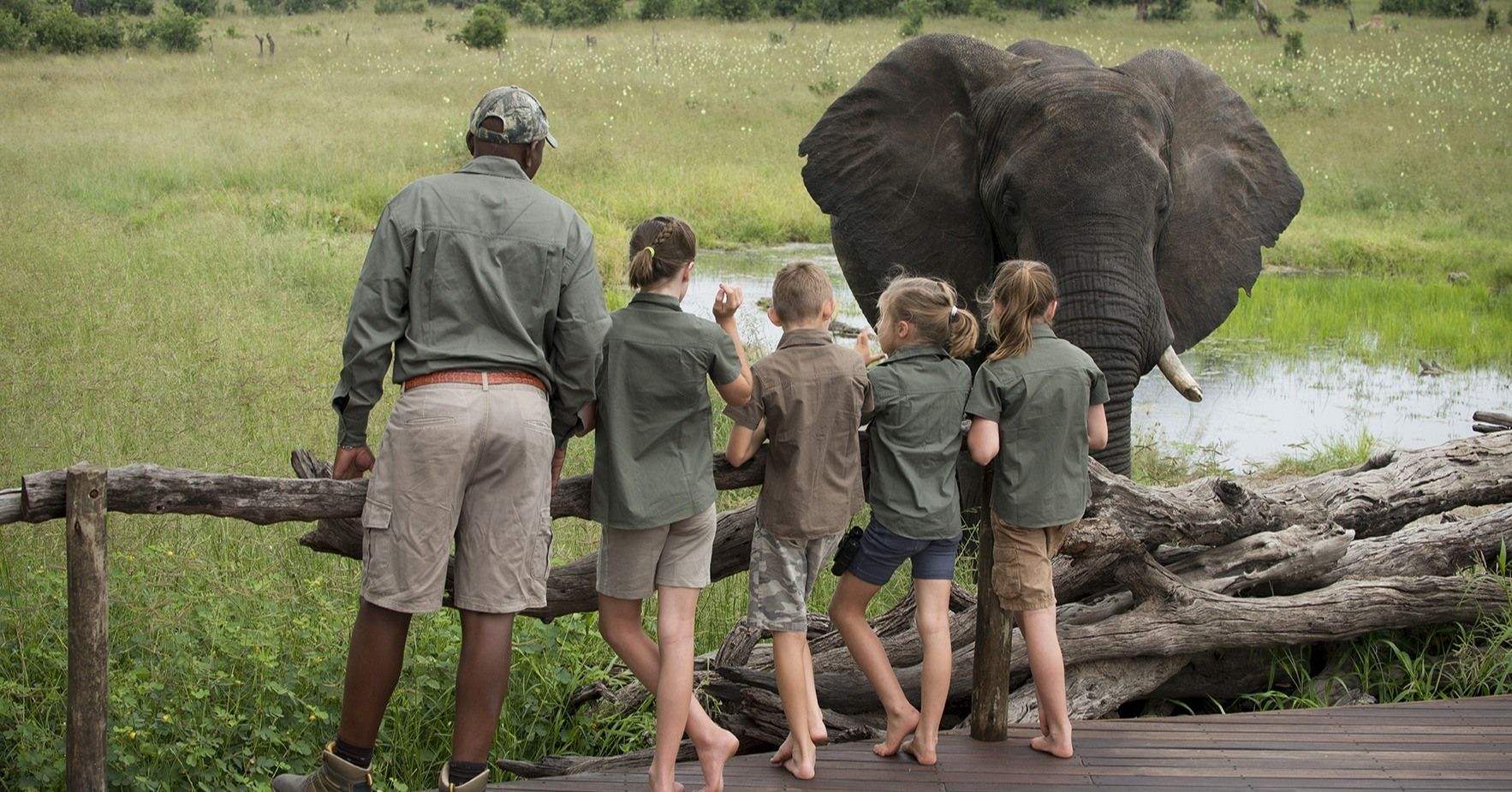 Family with safari guide in front of elephant